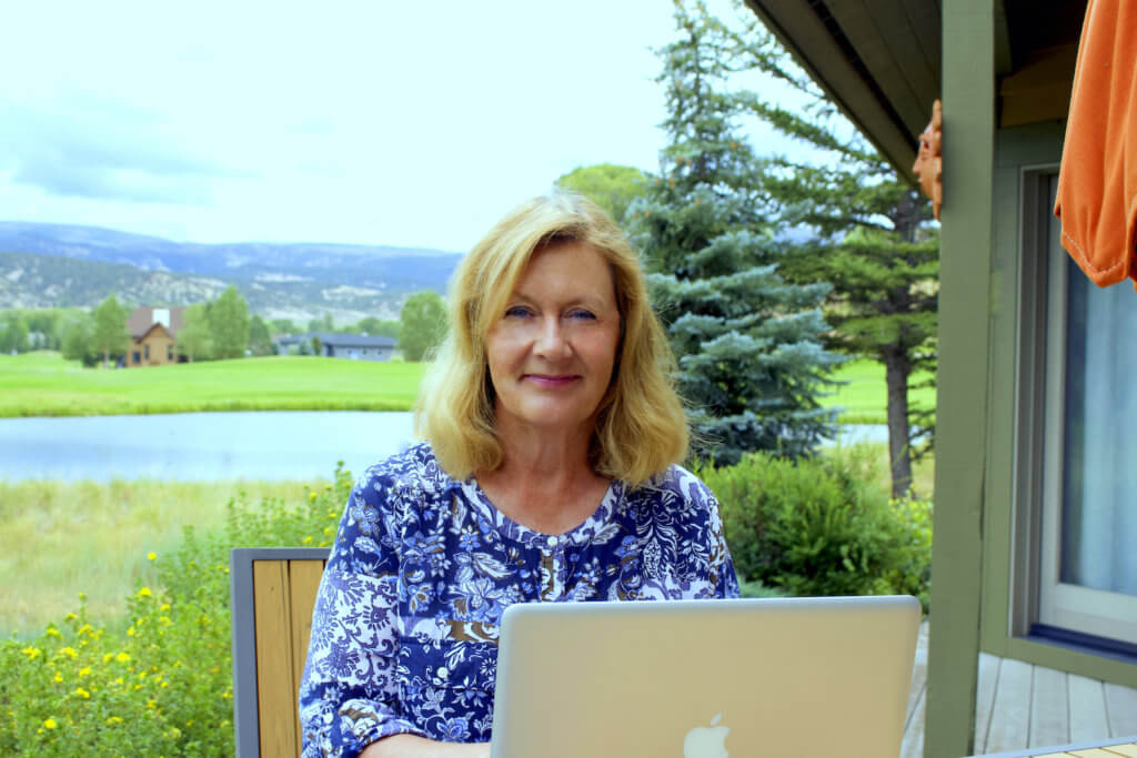 Shannon working on her laptop on the outside deck